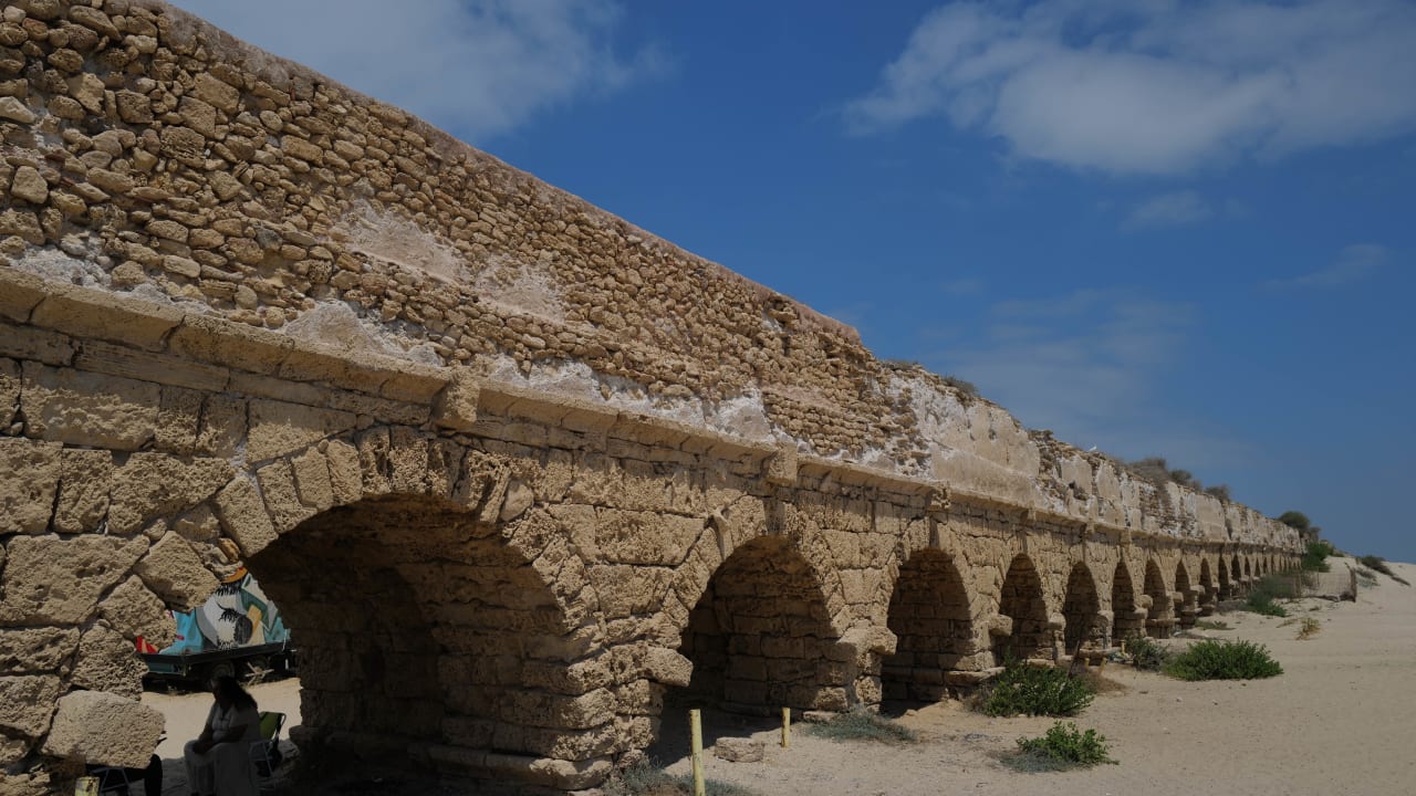 Israelis and tourists enjoy the beach near the 2,000-year-old Caesarea aqueduct, in Caesarea on August 21, 2023.