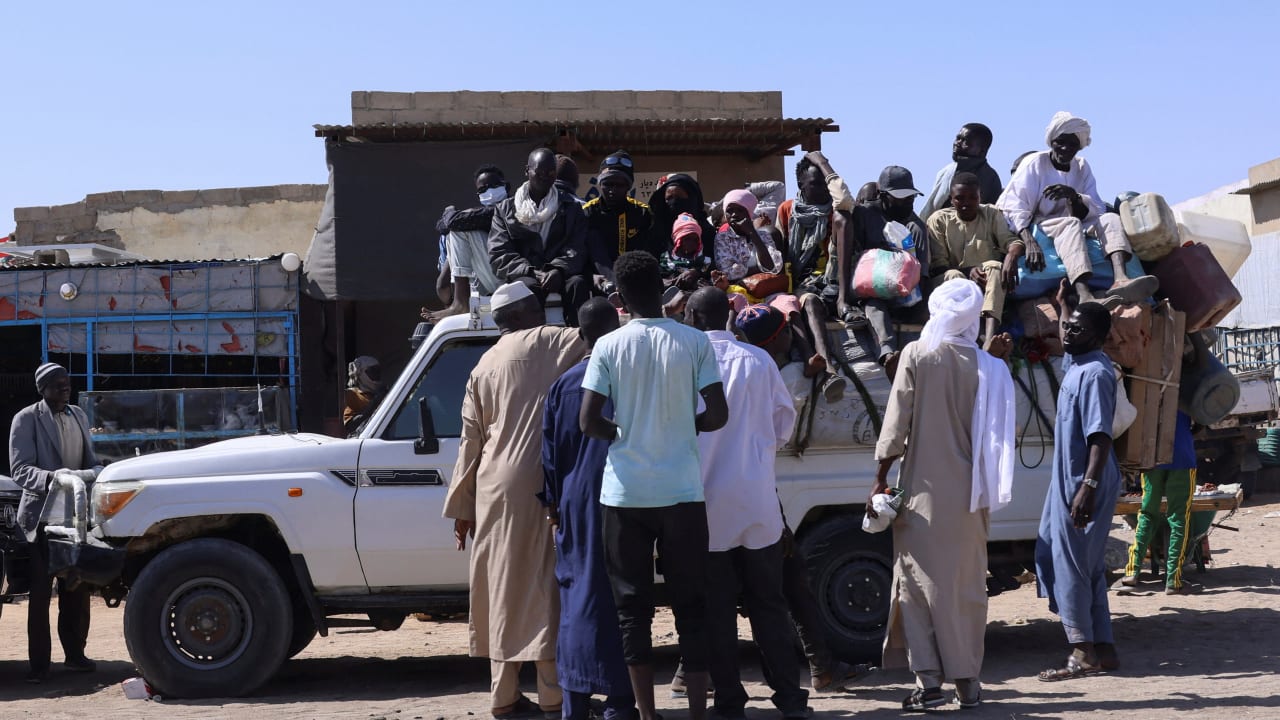 People sit on a pickup truck as they prepare to travel about 250 km south to Adre, on the Chad-Sudan border, at a transport station in Tine, eastern Chad, November 25, 2025. The movement comes amid the ongoing conflict between the paramilitary Rapid Support Forces (RSF) and the Sudanese army.