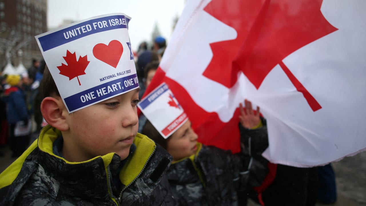 Children wear signs on their heads as they join demonstrators gathering in support of the Jewish community, on Parliament Hill in Ottawa, Ontario, in December 2023. 