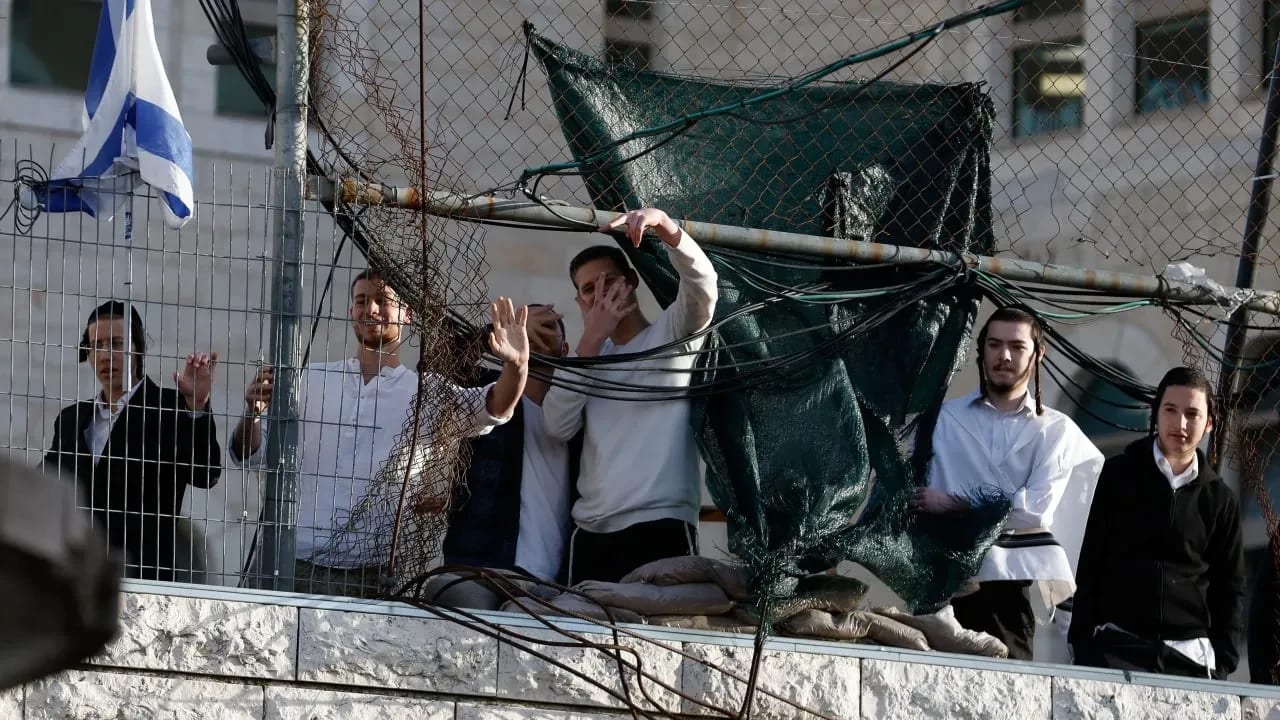 Colonos israelíes hacen gestos durante una visita semanal de colonos en Hebrón, en Cisjordania, el 7 de febrero de 2026. 