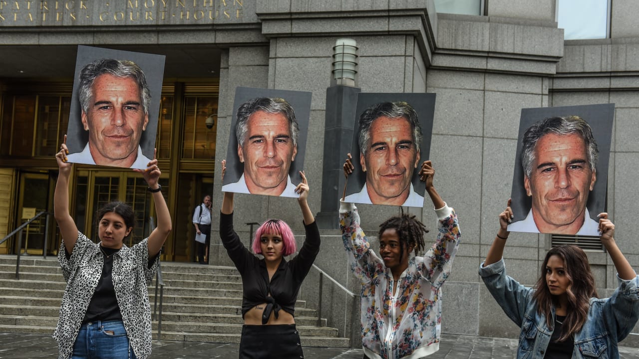 A protest group holds up signs of Jeffrey Epstein in front of the Federal courthouse on July 8, 2019 in New York City.