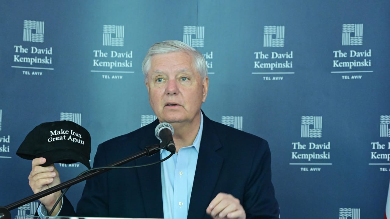 Senator Lindsey Graham holding a "Make Iran Great Again" hat during a speech at the David Kempinski hotel in Tel Aviv, February 16, 2026.