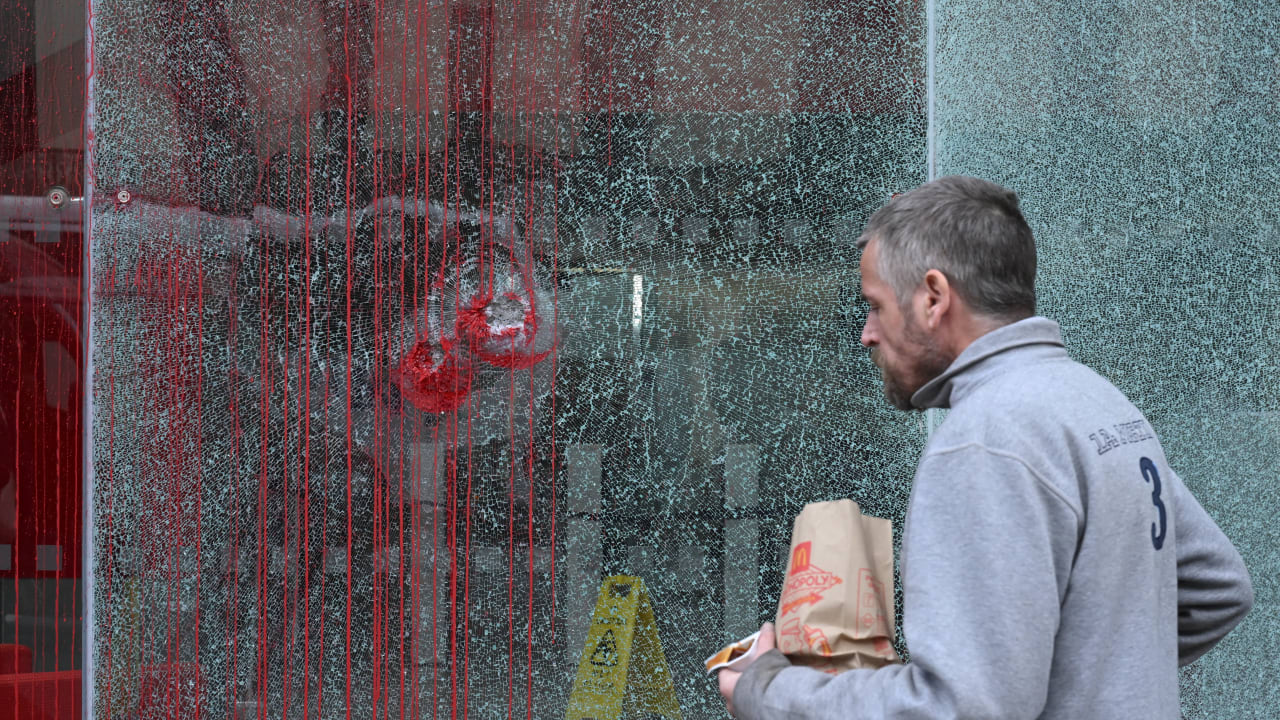 A man walks past a smashed window on the office building of Bain & Company after it was vandalised by pro-Palestine protesters during a demonstration over alleged ties to Israeli drone manufacturer Elbit Systems in London, Britain, September 16, 2025.