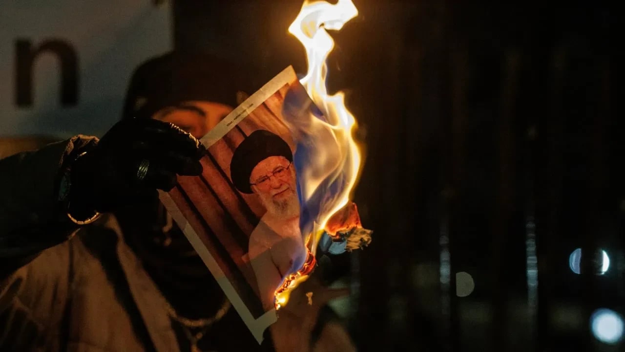 Un manifestante quema una imagen de Ali Khamenei, líder supremo de Irán, durante una protesta frente a la embajada iraní el 14 de enero de 2026 en Londres, Inglaterra.