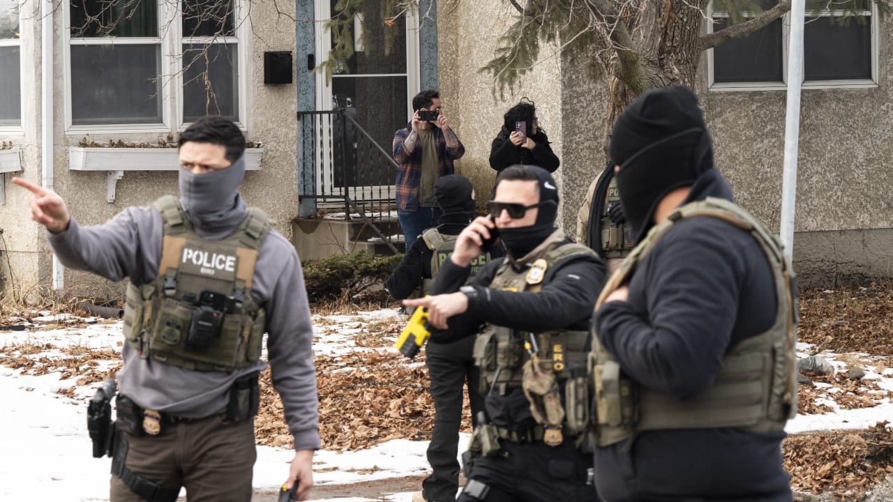 Observers film ICE agents as they hold a perimeter after one of their vehicles got a flat tire on Penn Avenue on February 5, 2026 in Minneapolis, Minnesota