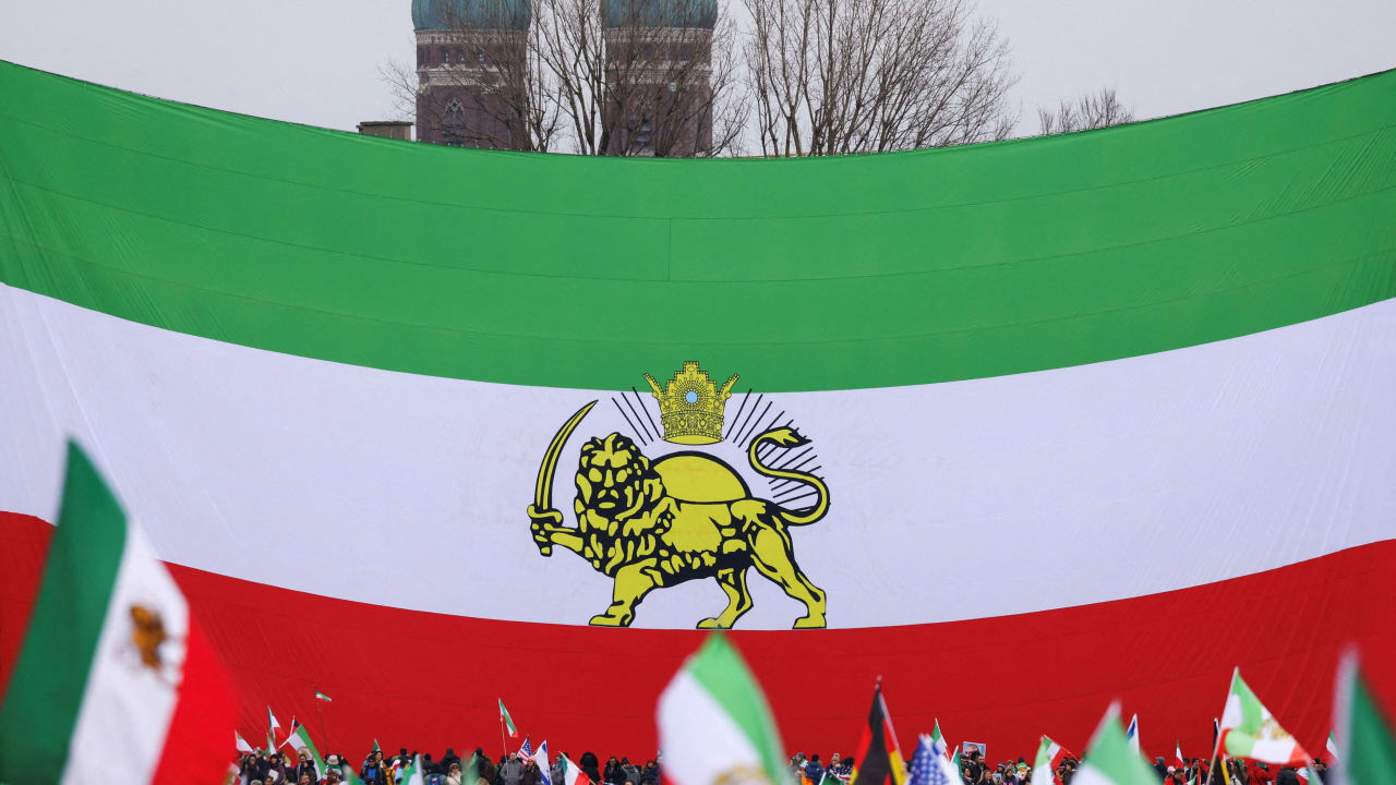 Protesters gather under a huge "Lion and Sun" pre-Iranian Revolution national flag, placed in front of Munich’s famous Church of Our Lady Liebfrauenkirche, during a demonstration organised by The Munich Circle calling for a free Iran, during the Munich Security Conference (MSC), in Munich, Germany. 