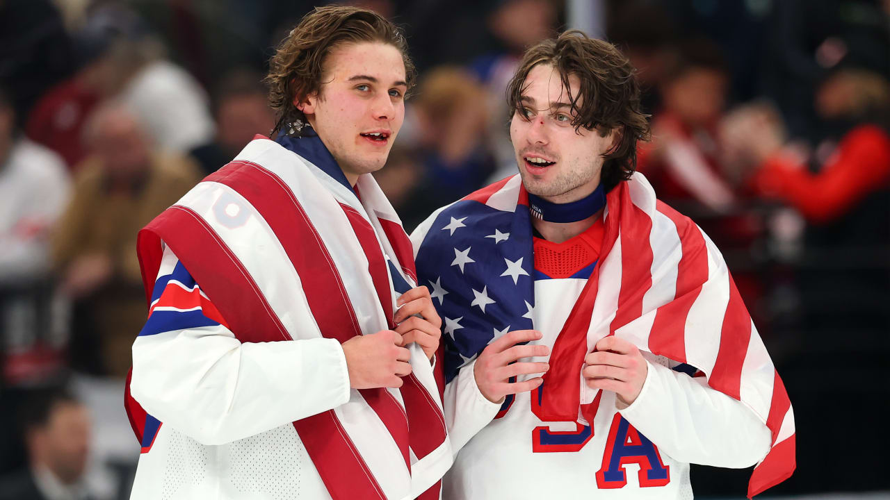 Jack Hughes #86 and Quinn Hughes #43 of Team United States celebrate winning the gold medals after the team's 2-1 overtime victory in the Men's Gold Medal match between Canada and the United States in Milan, Italy, on February 22, 2026.