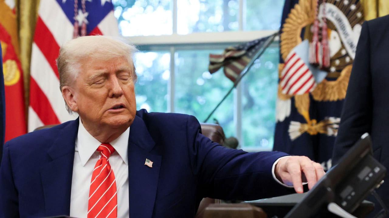 US President Donald Trump reaches for his phone as he makes an announcement in the Oval Office, White House, May 8, 2025; illustrative.