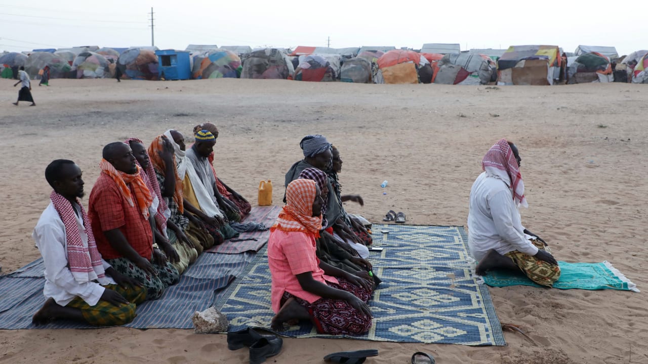 Internally displaced Somali men pray before Iftar outside their makeshift shelter after fleeing drought in the Lower Shabelle region to the camp in Mogadishu, Somalia, February 20, 2026.