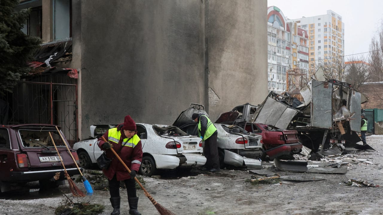 Municipal workers remove debris next to damaged cars outside an apartment building hit by a Russian drone strike on Thursday, amid Russia's attack on Ukraine, in Kharkiv, Ukraine February 26, 2026