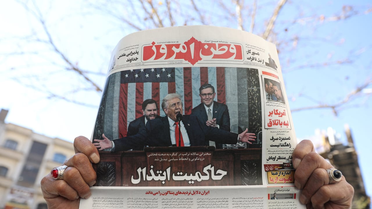 A man shows a newspaper with a front-page photo depicting US President Donald Trump delivering the State of the Union address, in Tehran, Iran, February 26, 2026