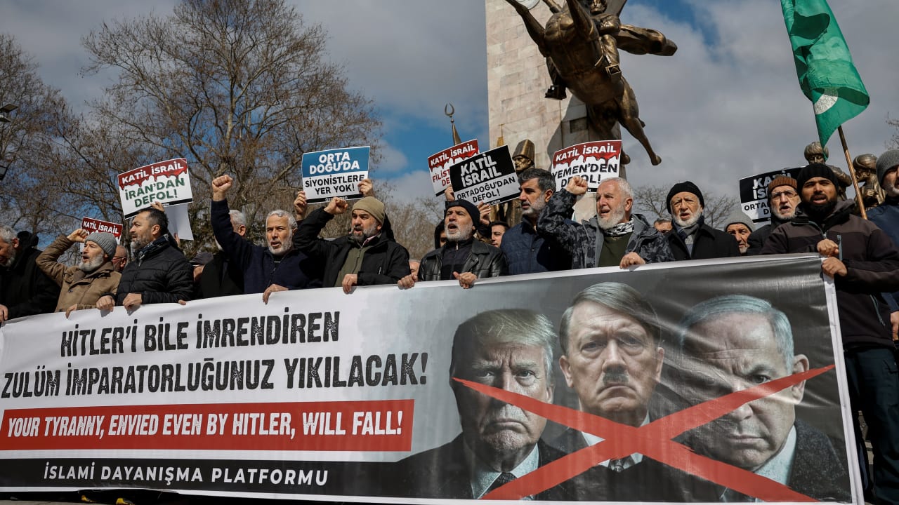 Demonstrators shout slogans as they hold a banner with the images of US President Donald Trump, Israeli Prime Minister Benjamin Netanyahu and Adolf Hitler during a protest after late Iran’s Supreme Leader Ayatollah Ali Khamenei was killed in Israeli and US strikes, in Istanbul, March 1, 2026.