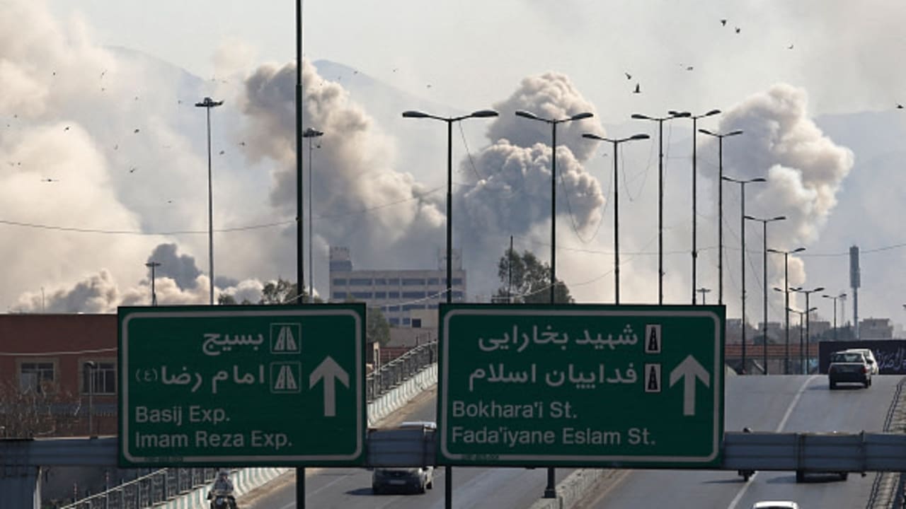 Motorists drive along an expressway as plumes of smoke rise after a strike in Tehran on March 5, 2026.