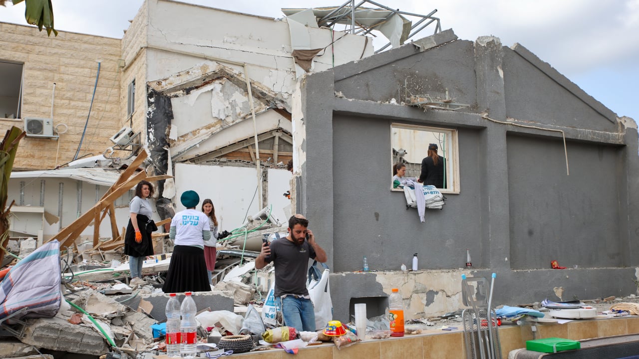 ISRAELIS VOLUNTEER at the site where a missile fired from Iran hit and caused major damage in Beit Shemesh, outside of Jerusalem, March 4, 2026.