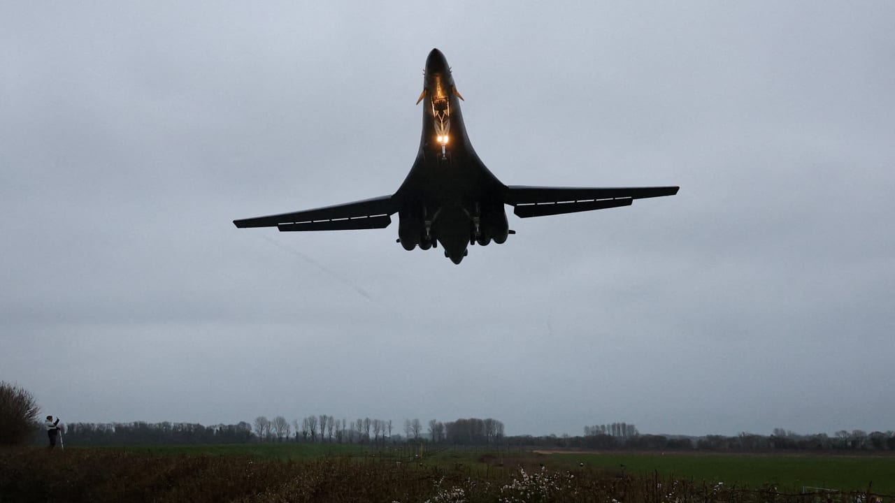 A person looks up as a USAF B1-B bomber prepares to land at RAF Fairford airbase, which also hosts United States Air Force (USAF) personnel, amid the US–Israeli conflict with Iran, in Fairford, Britain, March 6, 2026.