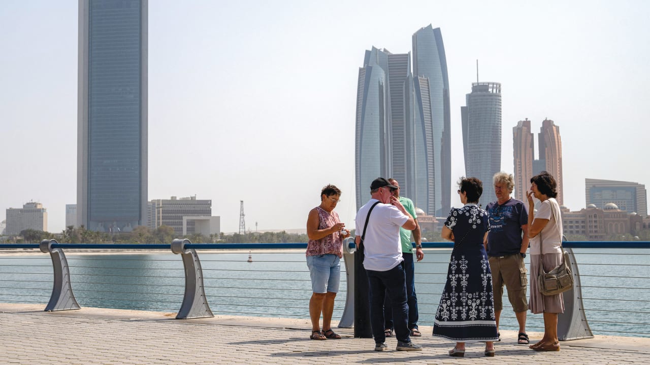 TOURISTS STAND near Etihad Towers in Abu Dhabi last week shortly after an Iranian missile attack.