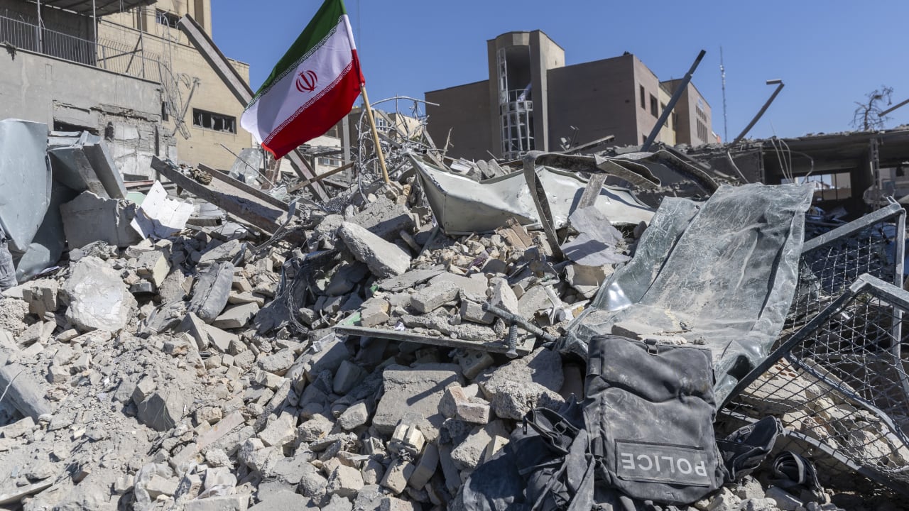 An Iranian flag is planted in the rubble of a police station, damaged in airstrikes yesterday, on March 3, 2026 in Tehran, Iran.