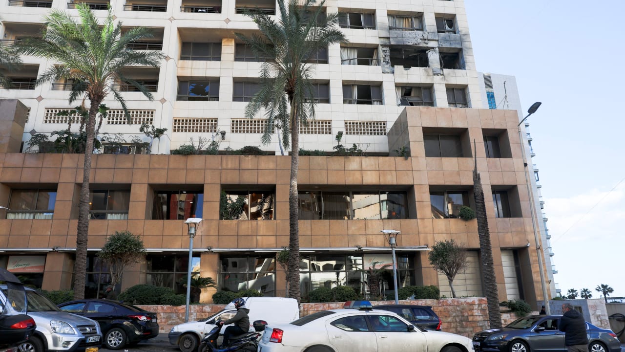 A police car passes by the damaged Ramada Plaza hotel building in the aftermath of an Israeli strike, in central Beirut, Lebanon, March 8, 2026