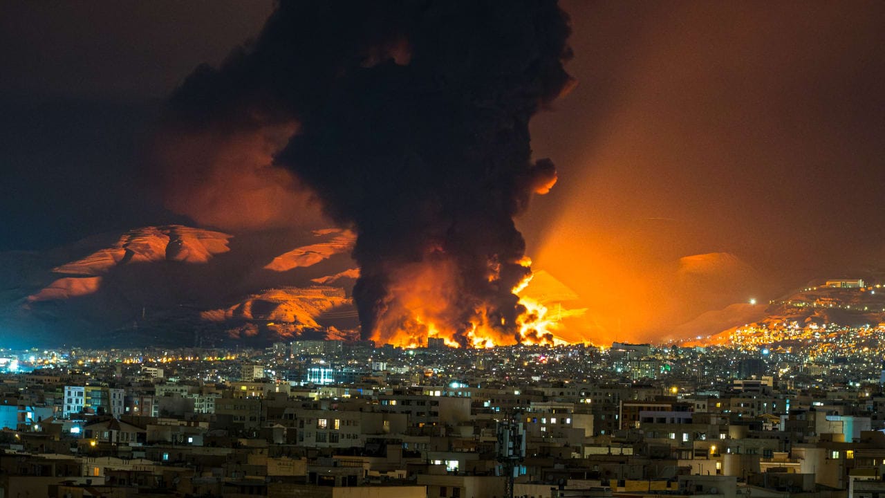 Smoke and flames rise at the site of airstrikes on an oil depot in Tehran on March 7, 2026. 