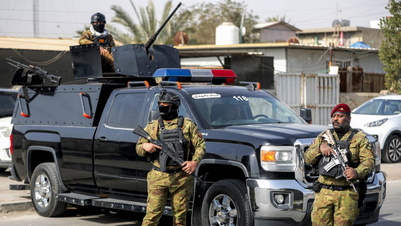 Iraqi security forces stand guard during a funerary procession for a slain member of Iraq's Hashed al-Shaabi,  in Baghdad on March 8, 2026.