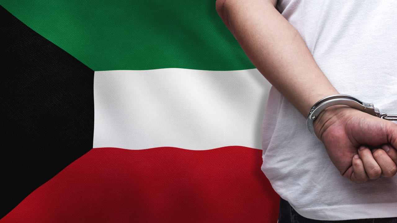 An illustration of a man in handcuffs with a Kuwaiti flag in the background.