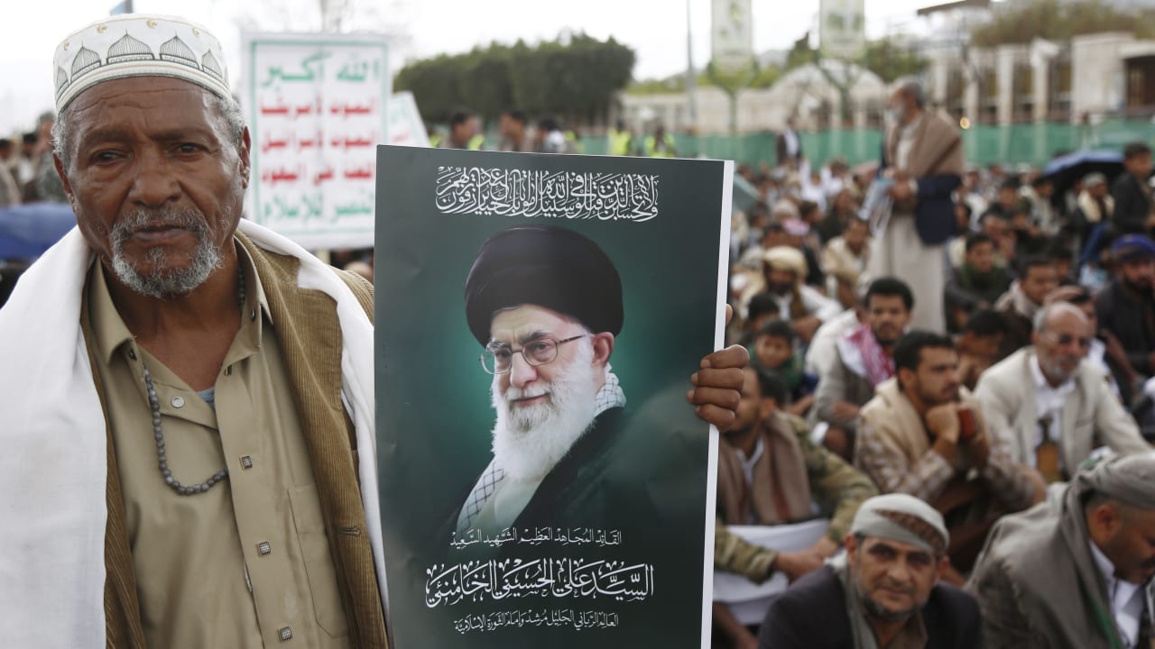 A Yemeni man holds a posters depicting the former Iranian Supreme Leader Ali Hosseini Khamenei during a rally by Houthi supporters on International Quds Day on March 13, 2026 in Sana'a, Yemen.