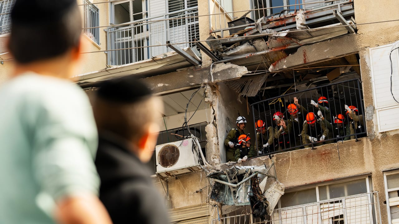 Israeli emergency services work on a balcony after damage to two apartments following the impact of an Iranian projectile on March 15, 2026 in Bnei Brak, Israel.