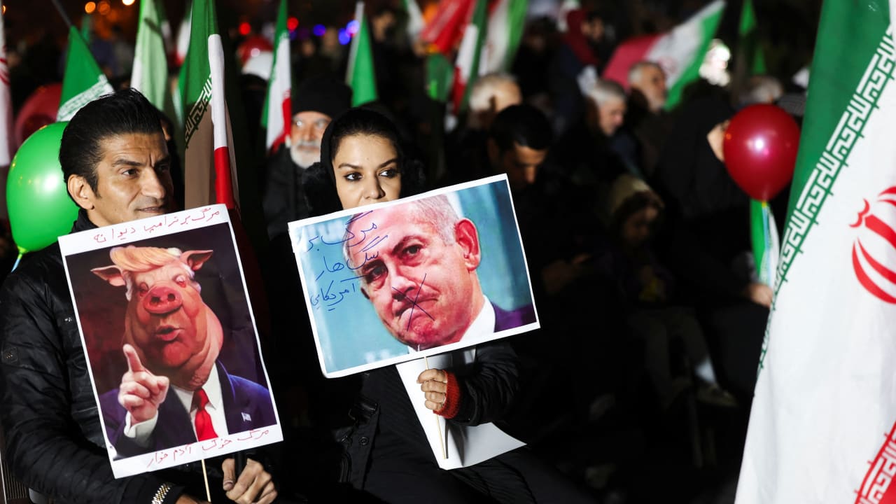 People hold signs depicting US President Donald Trump and  Prime Minister Benjamin Netanyahu during an anti-US and anti-Israel rally at Valiasr Square, in Tehran, Iran, March 17, 2026