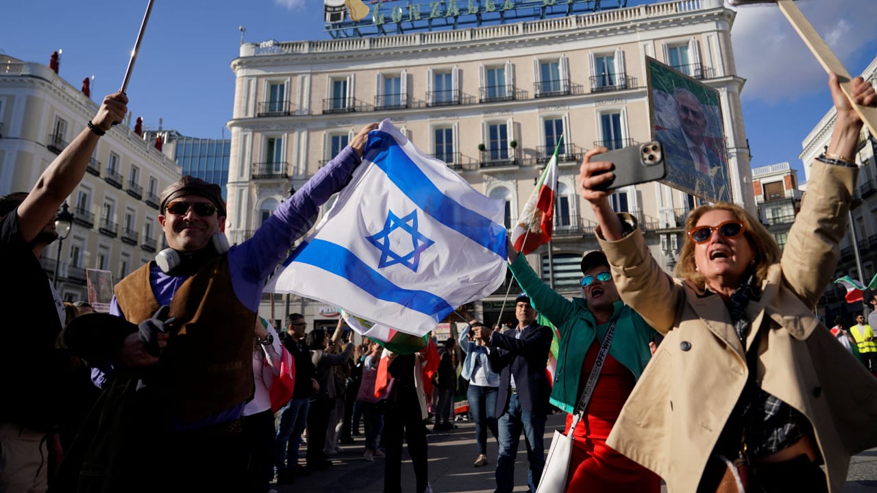 Members of the Iranian diaspora hold an Israeli flag during a protest in Puerta del Sol square in support of the Iranian people, following strikes by the U.S. and Israel against Iran, in Madrid, Spain, February 28, 2026.
