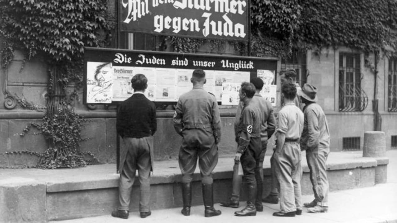 Germans read an antisemitic tabloid on a billboard: 'The Jews are our misfortune.' That was in 1935. The Palestinian Authority still teaches hate and violence toward Jews today, the author writes.