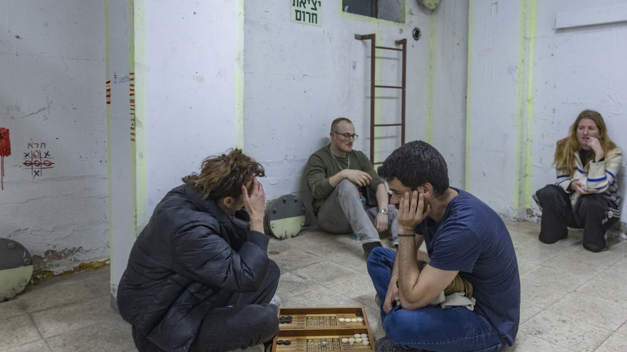 People take cover in a bomb shelter from incoming missiles fired from Iran in Tel Aviv, March 16, 2026.