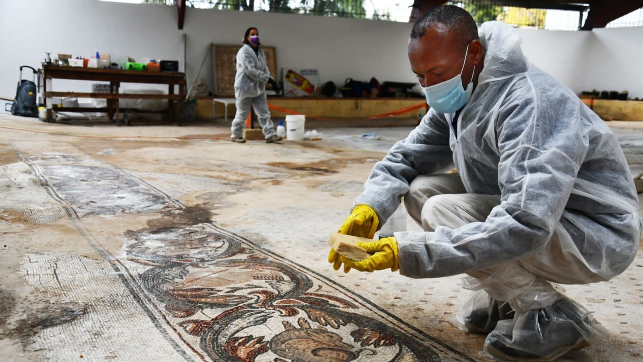 Man cleaning the Byzantine-era mosaic in Nahariya, taken in 2022; file photo.