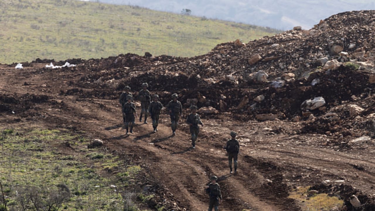 : Israeli soldiers walk along the buffer zone between Northern Israel and Southern Lebanon as seen from a position on the Israeli side of the border on February 18, 2025 in Northern Israel, Israel.