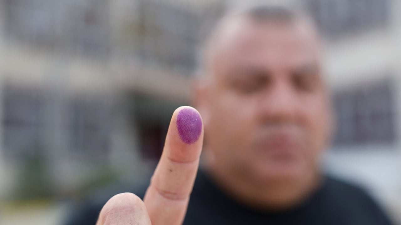 A Palestinian man shows his ink-stained finger after voting in a municipal council election, in Al Bireh, in the West Bank, April 25, 2026.