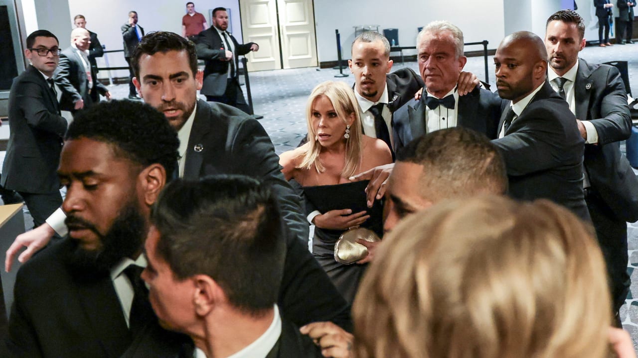 Security officials evacuate U.S. Health and Human Services (HHS) Secretary Robert F. Kennedy Jr. and his wife, Cheryl Hines, as a shooter opens fire during the annual White House Correspondents' Association dinner in Washington, D.C., U.S., April 25, 2026.