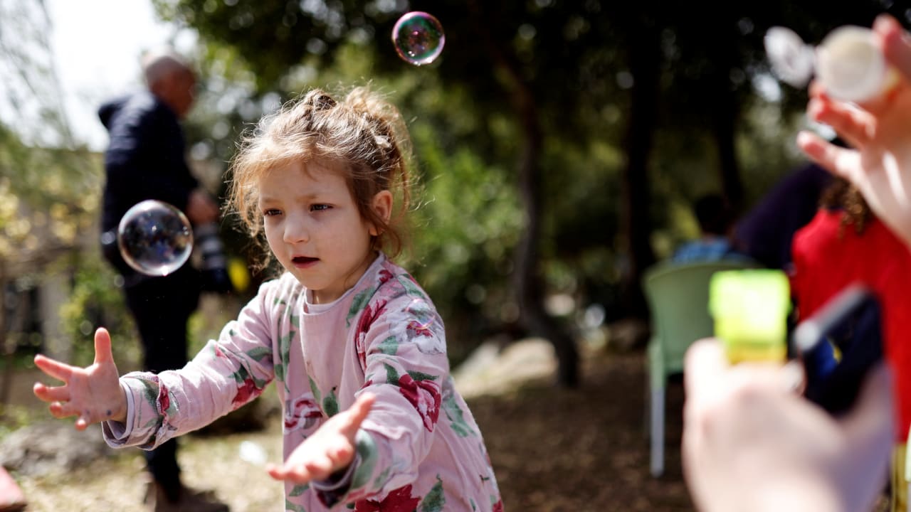 Shayna, a Jewish Ukrainian refugee from the Alumim children's home in Zhytomyr, Ukraine, catches bubbles as part of celebrations of the Jewish holiday of Purim after arriving to Israel following Russia's invasion of Ukraine.
