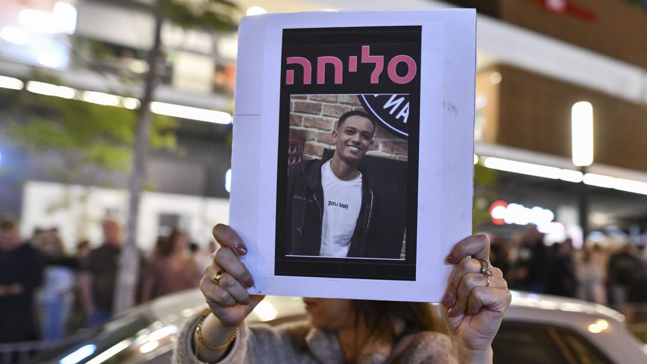 People gather outside a Pizza Hut branch in Petah Tikva, lighting candles and placing flowers in memory of employee Yemanu Binyamin Zalka, who was stabbed and later died of his wounds on the eve of Independence Day, April 25, 2026. 