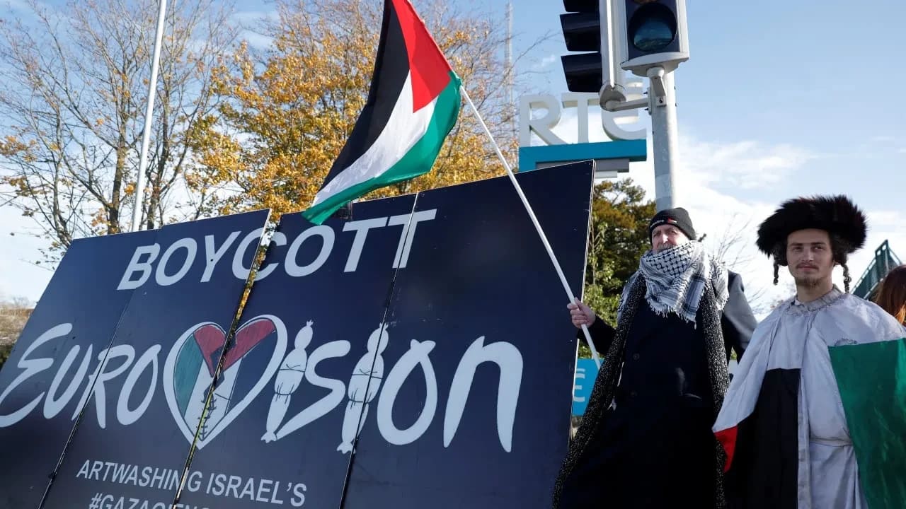 Manifestantes pro-palestinos sostienen una bandera y una pancarta frente a los estudios de televisión de la cadena pública irlandesa RTE (Radio Telefis Eireann), mientras piden que Irlanda boicotee el Festival de Eurovisión de 2026 si Israel participa en él, en Dublín, Irlanda