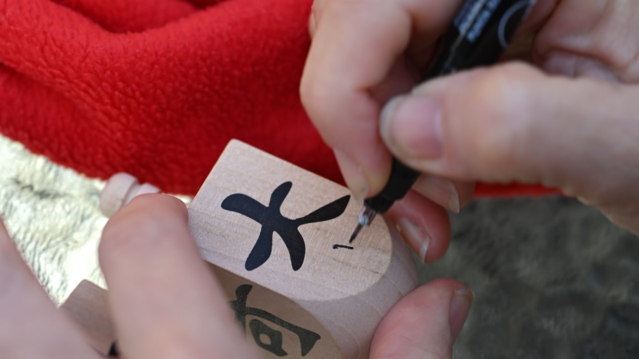 Adding Hebrew letters to a dreidel at the Shanghai Jewish Refugees Museum.