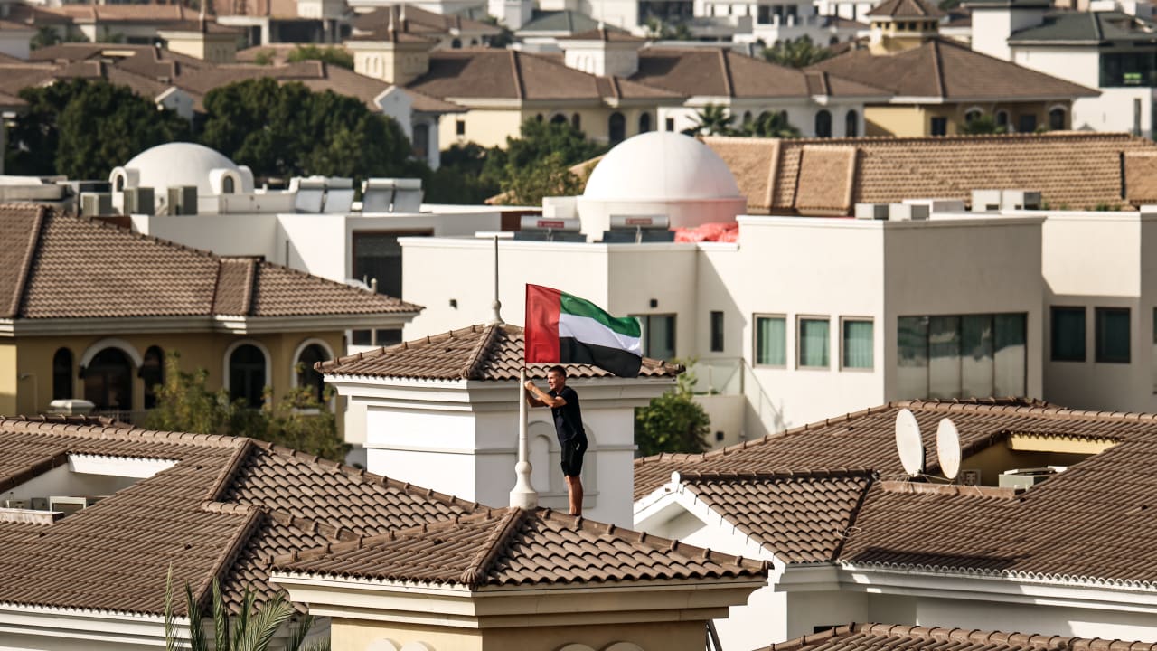 A man fixes the United Arab Emirates’ national flag to the roof of his house in Dubai, after a call by the UAE’s vice president, prime minister, and ruler of Dubai, urging people across the country to hoist the flag as a symbol of unity and pride.