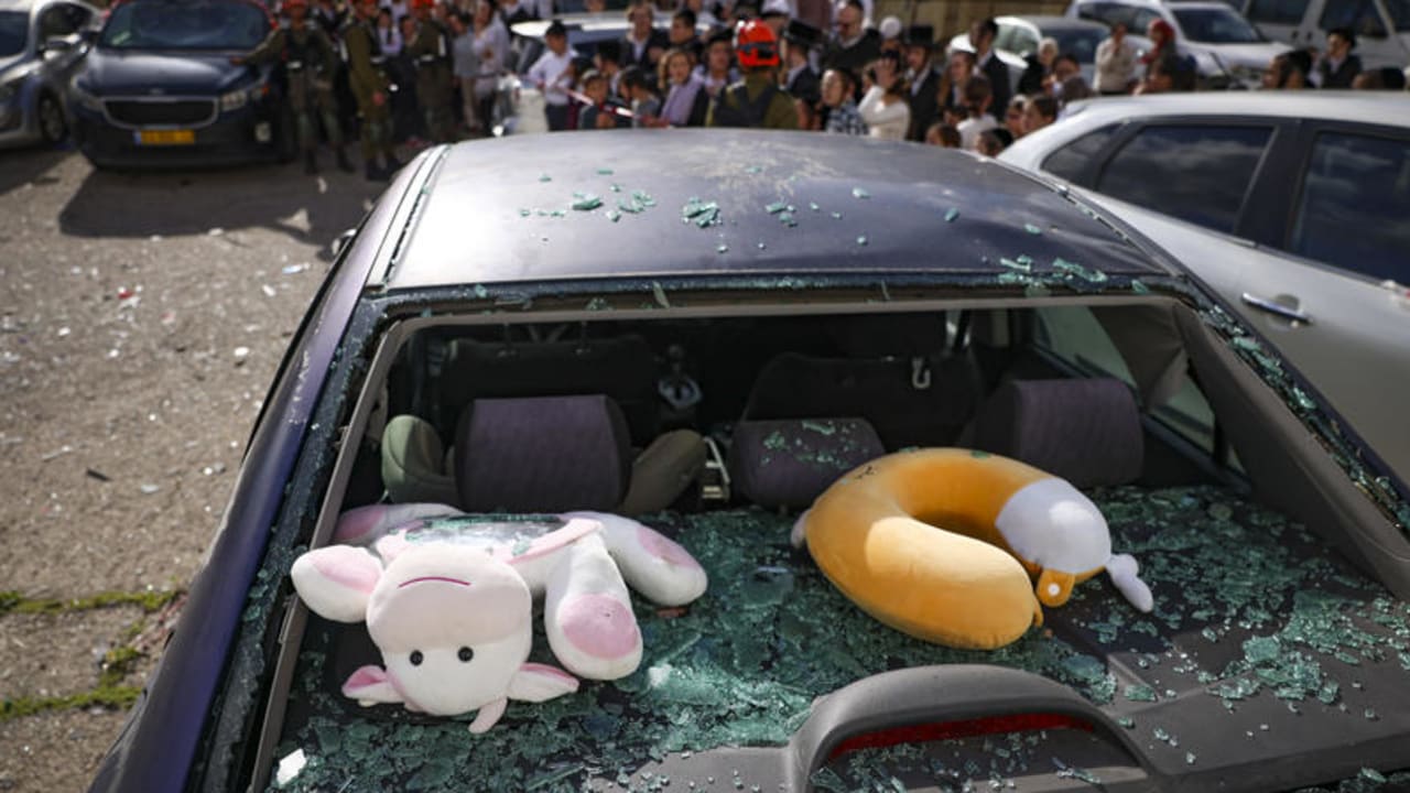 Civilians and security forces at the scene where a missile fired by Hezbollah from Lebanon struck a parking area in Safed, causing heavy damage, April 10, 2026. 