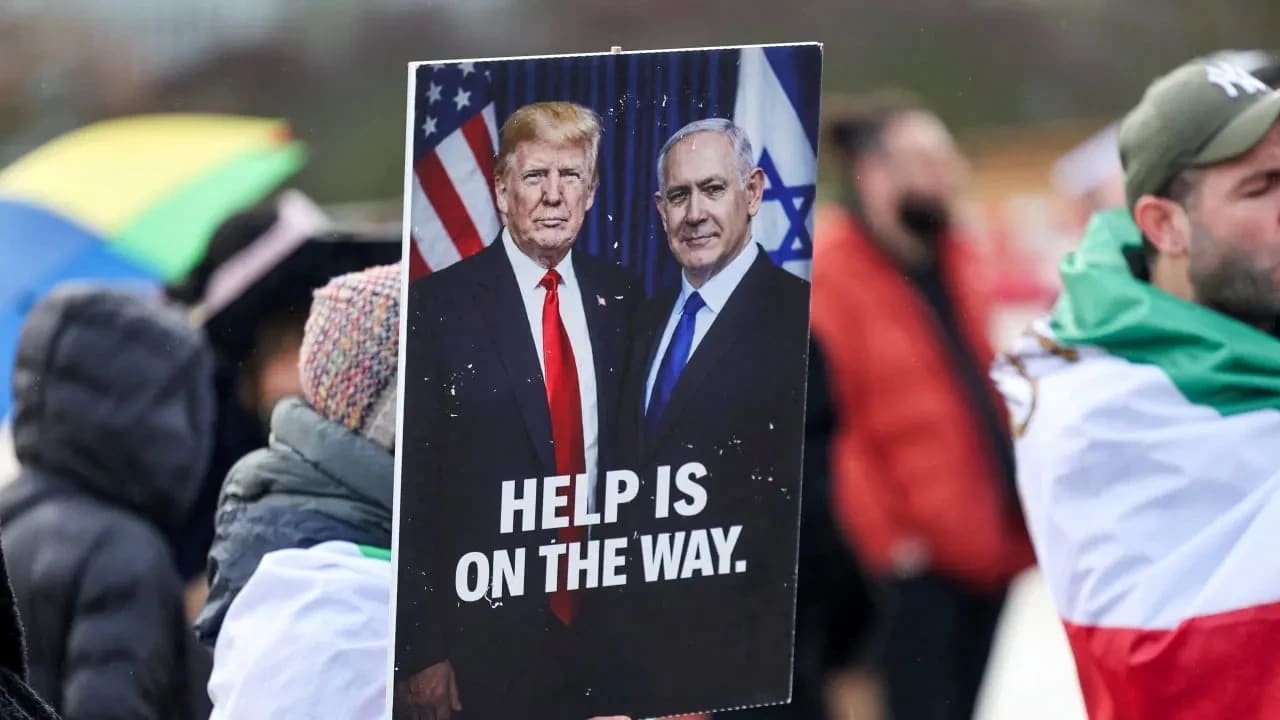 Una pancarta transmite un mensaje claro en la que aparecen el presidente de EE. UU., Donald Trump, y el primer ministro Benjamin Netanyahu, mientras los manifestantes se concentran cerca de la sede de la ONU durante las negociaciones nucleares entre EE. UU. e Irán, en Ginebra, el 17 de febrero. 