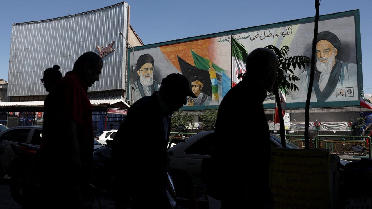 People walk past a mural depicting the late leader of the Islamic Revolution, Ayatollah Ruhollah Khomeini, and Iran's late Supreme Leader Ayatollah Ali Khamenei, in Tehran, Iran, May 25, 2026.