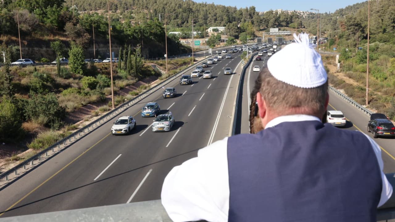A haredi man looks on as traffic builds at Hemed Interchange on Highway 1 amid ultra-Orthadox anti-draft protests, June 24, 2026.