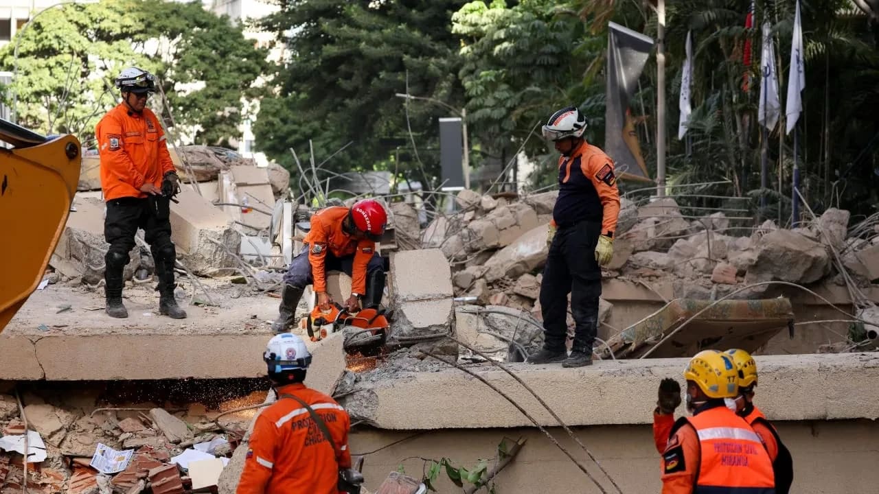 Los servicios de emergencia trabajan en el lugar donde se ha derrumbado un edificio tras los terremotos que han sacudido el país, en Caracas, Venezuela, el 25 de junio de 2026. 