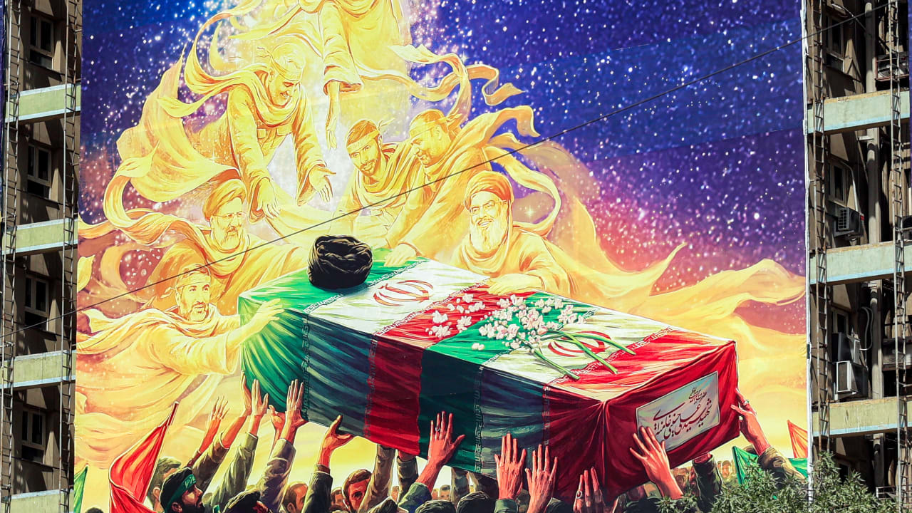 A mural depicts late figures aligned with the Iranian government, such as late President Ebrahim Raisi, slain IRGC commander Qasem Soleimani, slain Lebanese Hezbollah leader Hassan Nasrallah, and others, all carrying the flag-draped casket of Iran's slain supreme leader Ali Khamenei. June 29, 2026. 