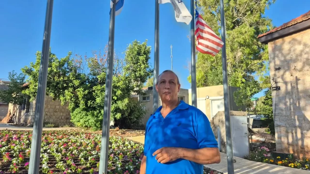 Metula Council Chairman David Azoulai stands next to the Israeli flag in defiance of the US president setting policy on the northern border, according to his claim