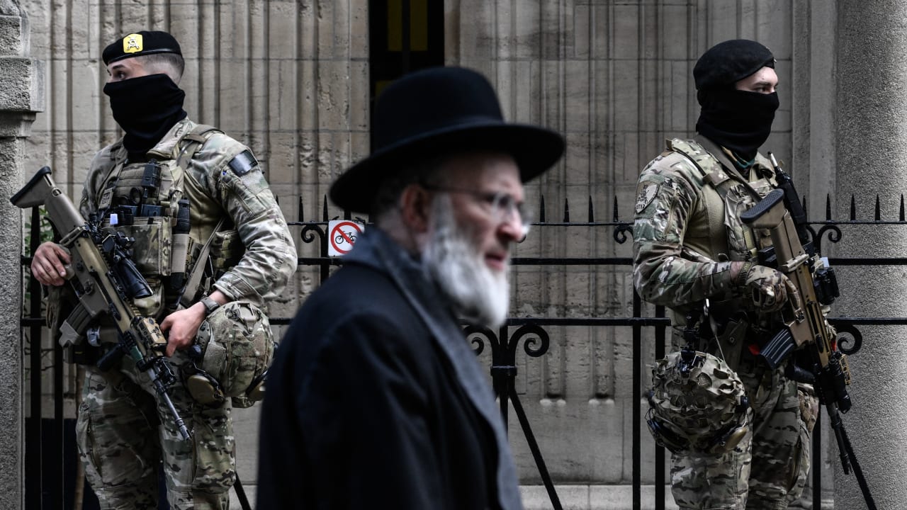 Belgian military personnel armed with assault rifles stand guard outside a synagogue in central Antwerp as part of Belgium’s reinforced security measures established at Jewish schools and synagogues, on March 23.