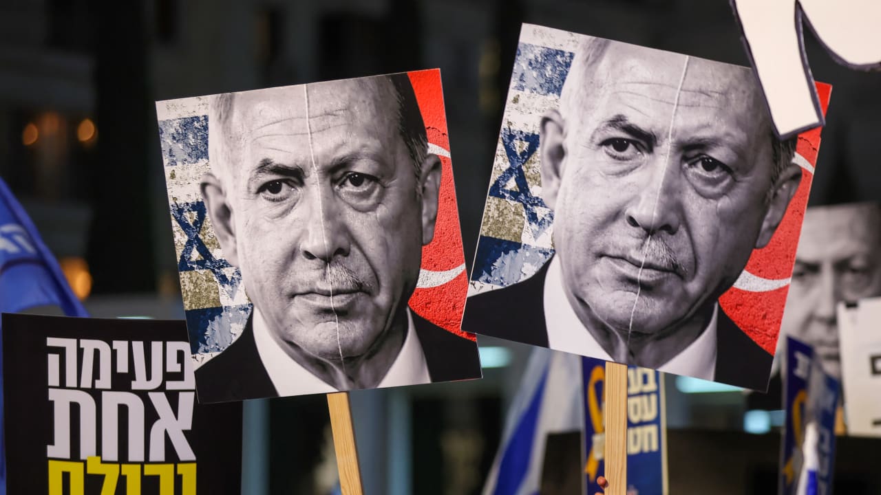 Demonstrators hold placards with portraits of Israeli Prime Minister Benjamin Netanyahu (L) and Turkish President Recep Tayyip Erdogan (R) during a protest.