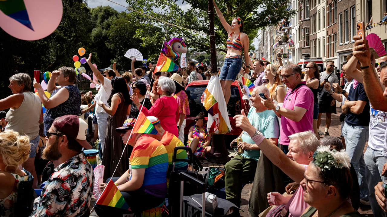 Participants and spectators cheer during the Canal Parade in Amsterdam on August 1, 2026; illustrative.